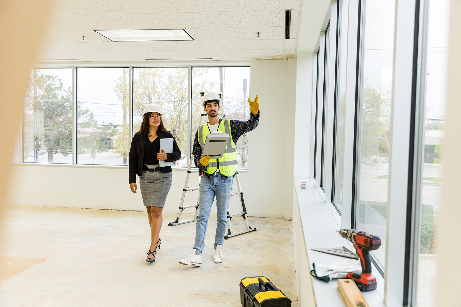 Construction workers discussing renovation in empty room.