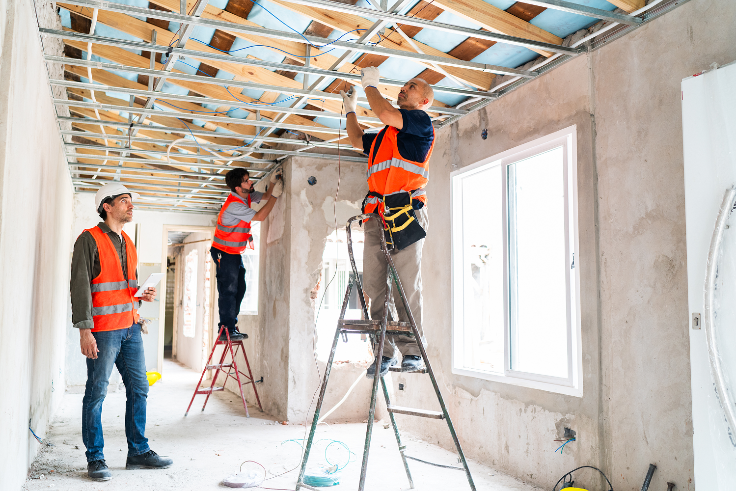 Construction workers installing ceiling framework.