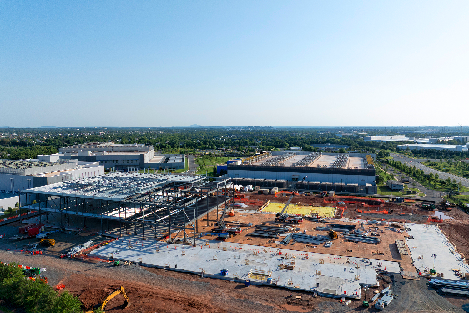 Construction site with steel framework and buildings.