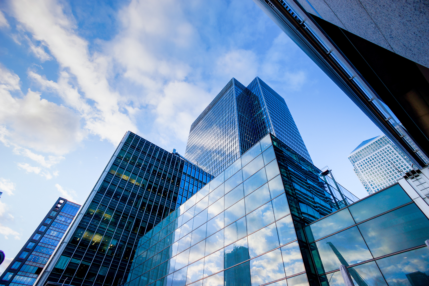Skyscrapers reflecting blue sky and clouds.