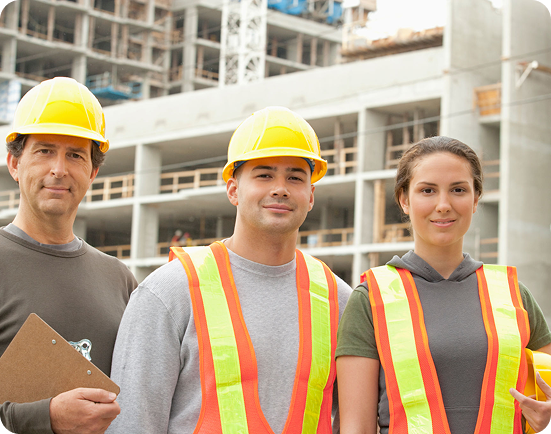 Construction workers in safety gear, building site.