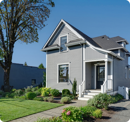 Gray house with garden and blue sky.