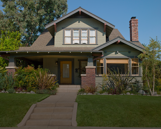 Green Craftsman house with front porch.